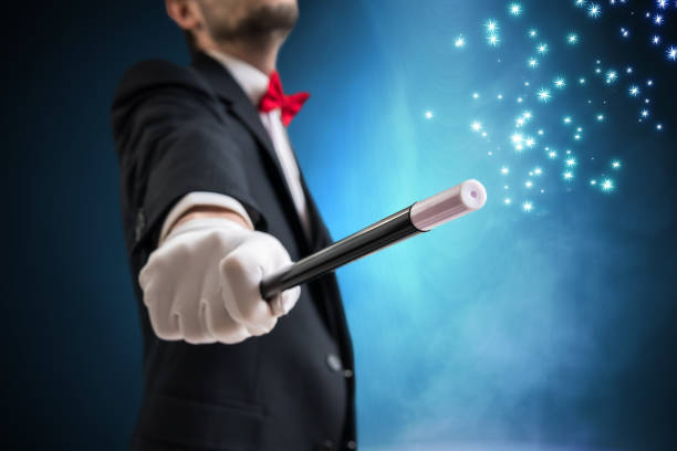 istock Magician or illusionist is showing magic trick. Blue stage light in background. 947220014