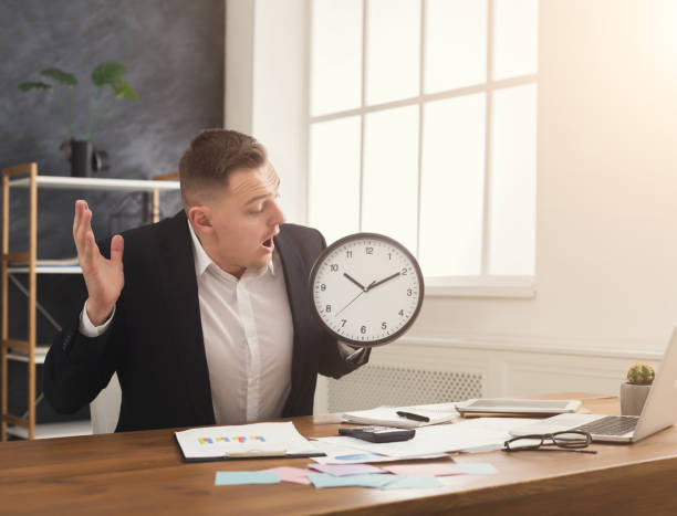 istock Businessman holding clock and pointing on it 947221294