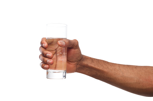Black male hand holding glass of water isolated on white background, closeup, cutout