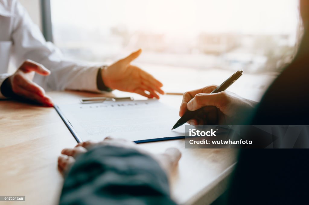 Dealer sales advice to the customer and guide to sign the contract. Contract Stock Photo