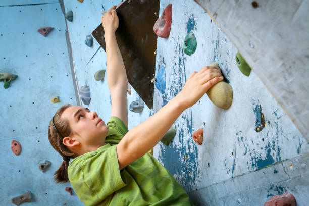 Teenage Boy Training Climbing On Indoor Climbing Wall stock photo