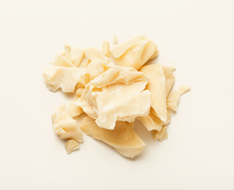 Pieces of cocoa butter isolated on white background. Heap of white chocolate, cutout