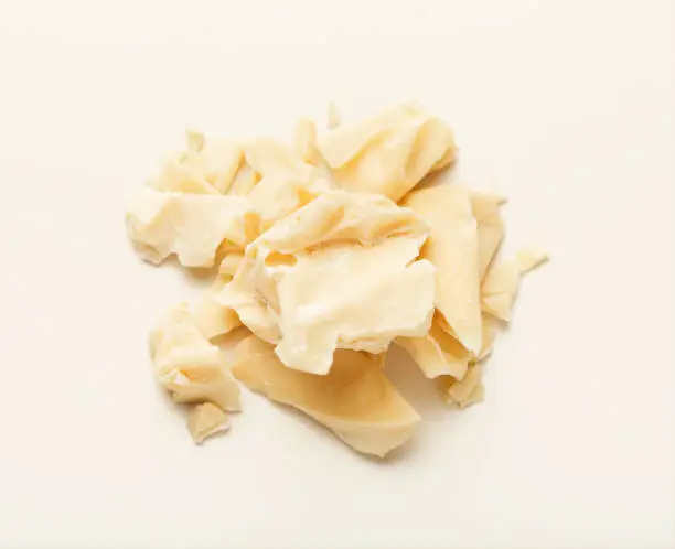 Pieces of cocoa butter isolated on white background. Heap of white chocolate, cutout