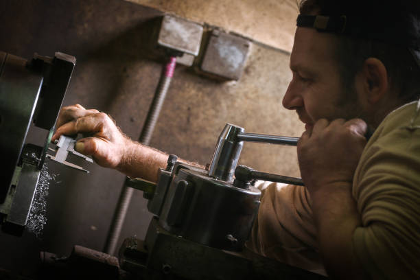istock Worker professionally measuring the shaped material on lathe 947229378