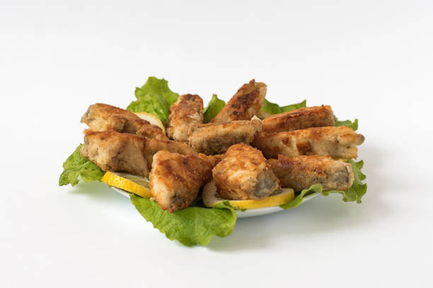 istock fried fish on a white plate with lettuce and lemon 947230330