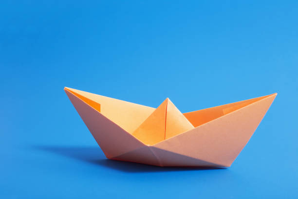 istock paper boat on blue paper background 947231024