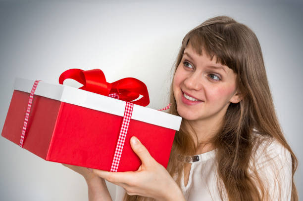 istock Pretty smiling woman with red gift box 947233864