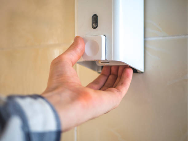 istock hand take liquid soap from a box on the wall to wash hands 947234446