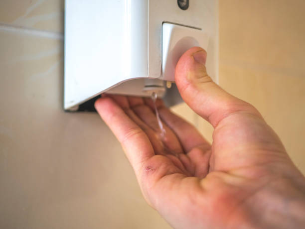 istock hand take liquid soap from a box on the wall to wash hands 947234482
