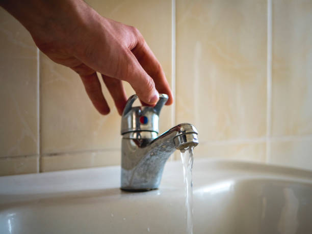 istock close up hand open water from the washbasin in the bathroom 947234530