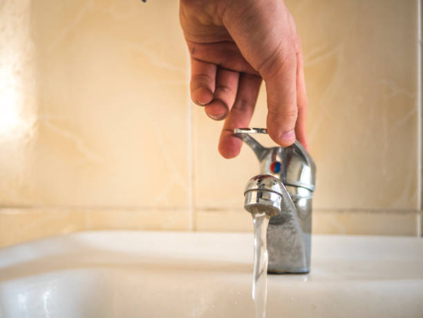 istock close up hand open water from the washbasin in the bathroom 947234540
