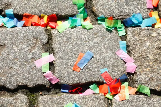 Colorful paper snippets lying on cobblestones