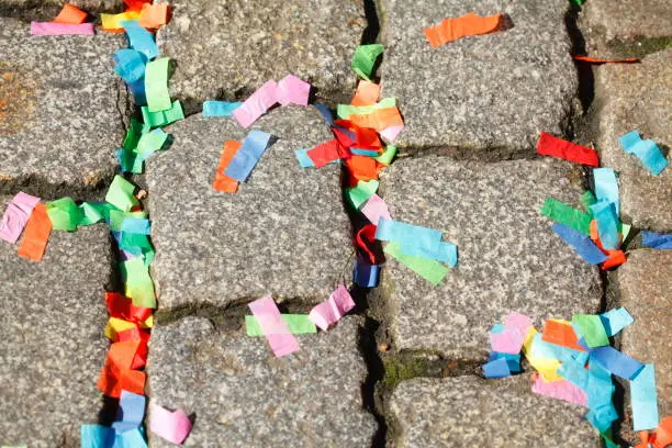 Colorful paper snippets lying on cobblestones