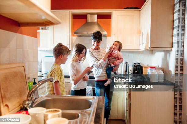 Photo libre de droit de Famille De Socialisation Dans La Cuisine banque d'images et plus d'images libres de droit de Polyvalence - Polyvalence, Mère, Femmes d'âge mûr