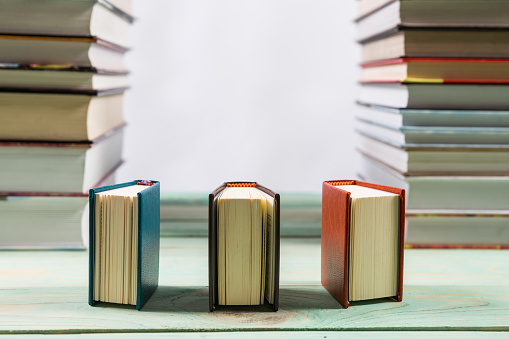 Pile of various books on bright wooden background. With copy space for your text