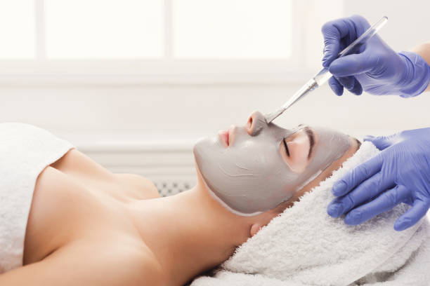 Woman gets face mask by beautician at spa