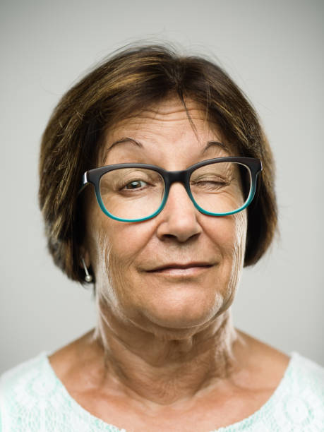 un clin de œil portrait véritable senior femme - raised eyebrows photos photos et images de collection