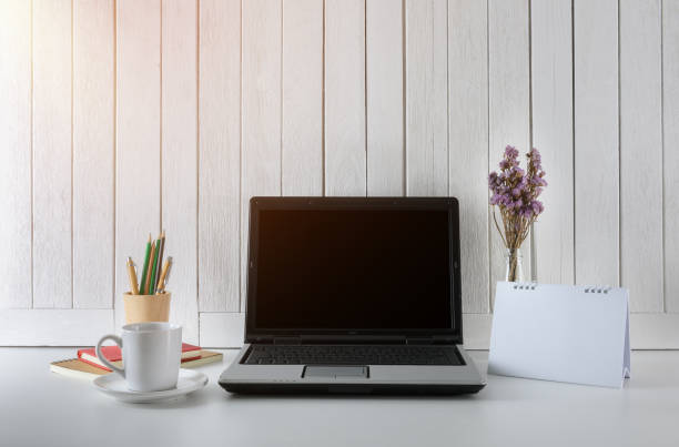 istock workplace background with Blank white screen modern laptop computer. White wooden vintage blackground 947253694