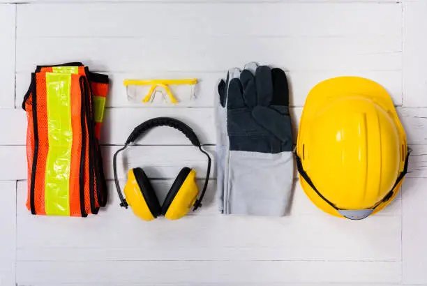 Photo of Standard construction safety equipment on wooden table. top view