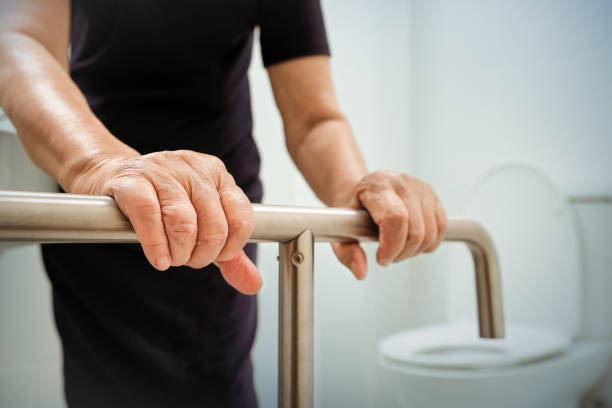 Elderly woman holding on handrail in bathroom. Elderly woman holding on handrail in bathroom. burglar bars stock pictures, royalty-free photos & images