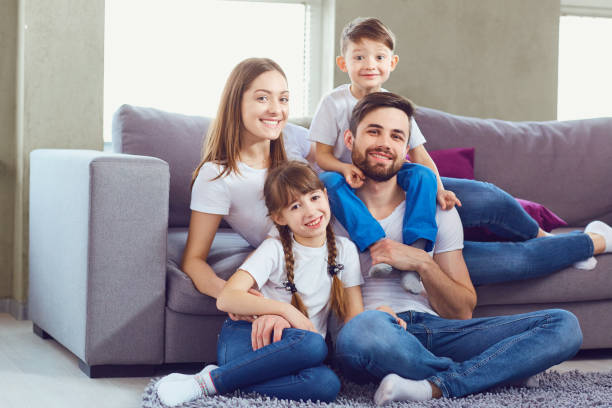 istock Happy family smiling sitting at home 947259888