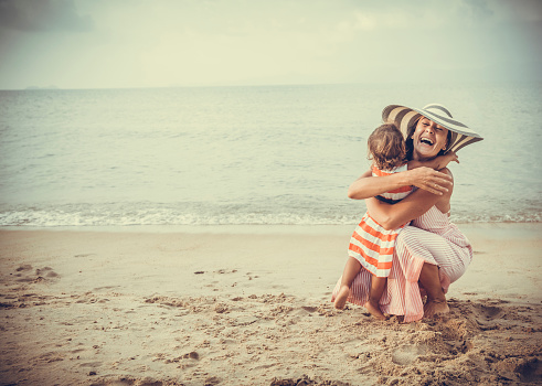 Mother and daughter embracing at the beach