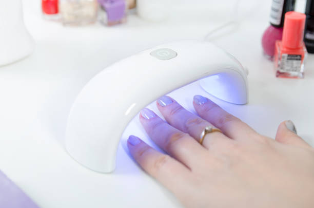 istock Woman using UV light dryer. Manicure, spa salon concept. 947264756