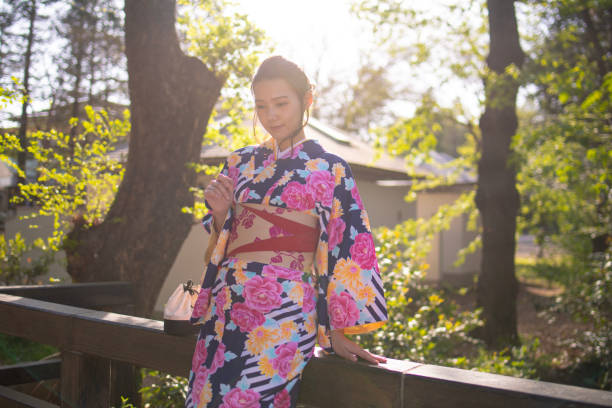 istock Young Asian woman in kimono visiting public park 947267380