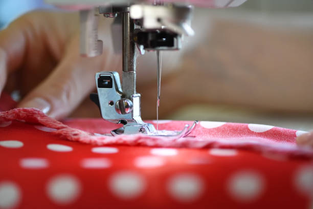 Sewing machine working part with red cloth Female hands on sewing machine. Close up of seamstress work atelier fashion photos stock pictures, royalty-free photos & images