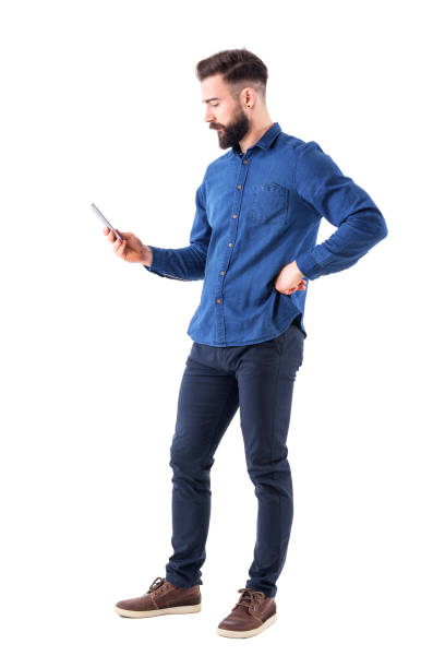 Young handsome well dressed business man surfing internet on smart phone. Side view Young handsome well dressed business man surfing internet on smart phone. Side view. Full body isolated on white background. full body isolated stock pictures, royalty-free photos & images