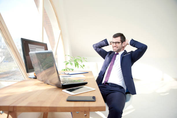 istock Confident young businessman relaxing at office desk 947278402