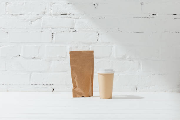 istock Front view of paper package of coffee and disposable cup 947278688