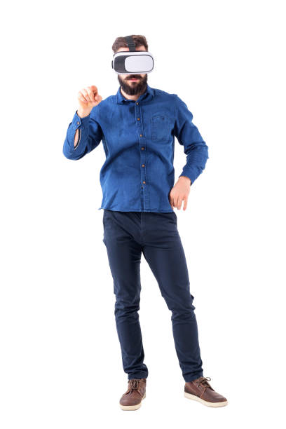 istock Front view of business man wearing vr glasses pointing finger at interactive touch screen. 947279134