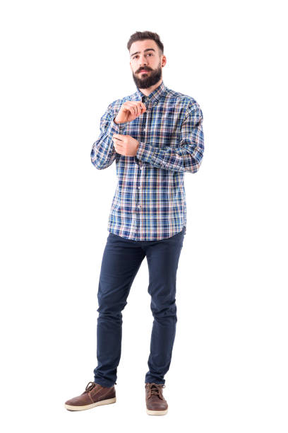 istock Young bearded man get dressed buttoning sleeve buttons and looking confidently at camera 947279602