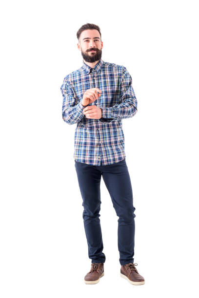 istock Confident smiling bearded business man getting dressed buttoning sleeve and looking at camera. 947279630