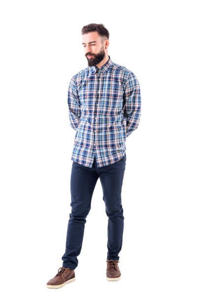 istock Disappointed skeptical bearded hipster with hands on back looking down 947279750