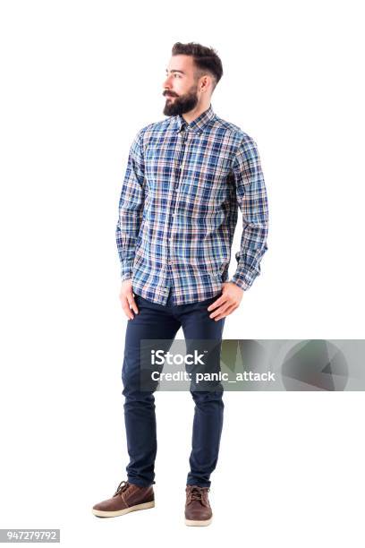 Confident Relaxed Bearded Handsome Fashion Model In Plaid Shirt With Thumbs In Pockets Looking Away Stock Photo - Download Image Now