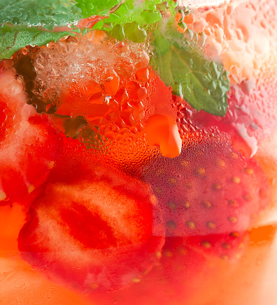 background pitcher of strawberry lemonade with water drops close-up
