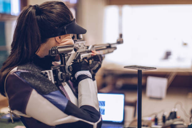 Woman on rifle shooting training One woman, girl sport shooter aiming with a rifle on target shooting training. female sharp shooter stock pictures, royalty-free photos & images