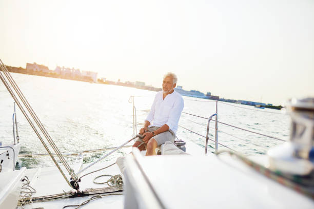 istock Mature man out sailing on a sunny afternoon 947295572