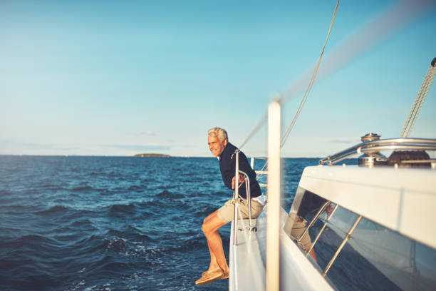 그의 요트에서 바다 전망을 감상 하는 성숙한 남자 - sailboat sea retirement adventure 뉴스 사진 이미지