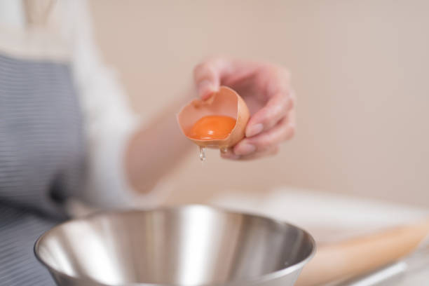 istock Closeup of woman's hand dividing egg 947299390