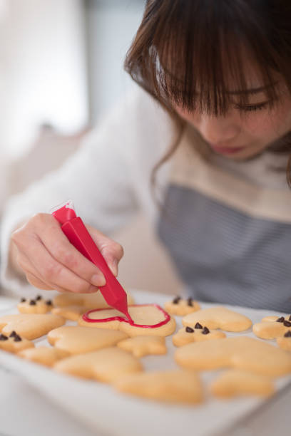 istock Woman painting on cookie in kitchen 947299706