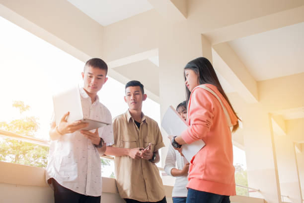 istock Education learning Concept : Students or Startup business Young  Asian College groups using tablet to studying together with documents paper for report or assignment in Outside classroom at university 947304104
