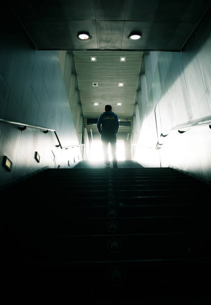 istock Man walking up to sunlight in dark passageway 947307500