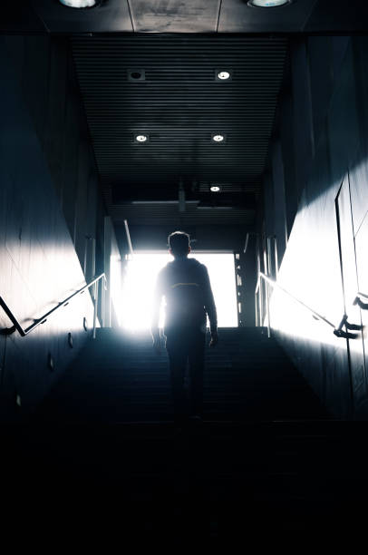 istock Man walking up to sunlight in dark passageway 947307510