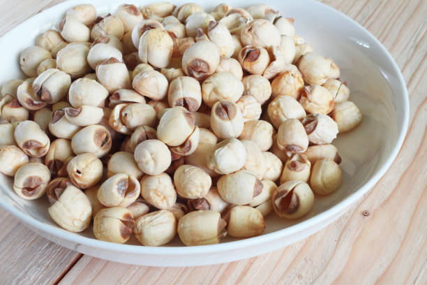 istock Lotus seed on white plate with background wood table. 947307772