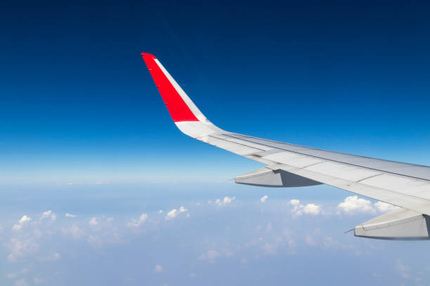 istock airplane wings in the blue sky with clouds 947308570