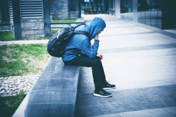 istock Sad man sitting on city street 947308756