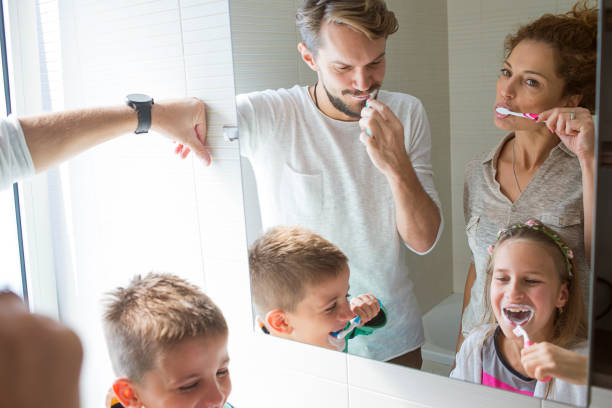istock young family brushing teeth together 947313912